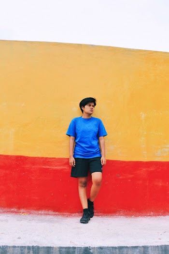 Photo of Man Leaning on Painted Concrete Wall