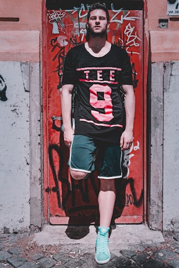 Photo of Man Leaning On Red Metal Door