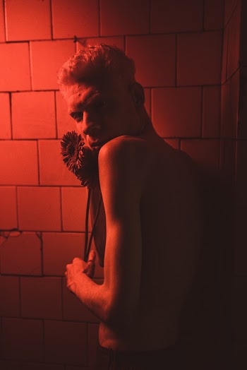 Photo Of Man Leaning on White Tiles