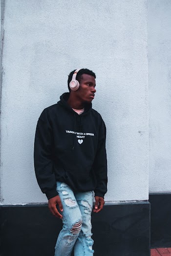 Photo Of Man Leaning On White Wall