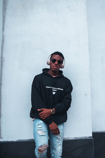 Photo Of Man Leaning On White Wall