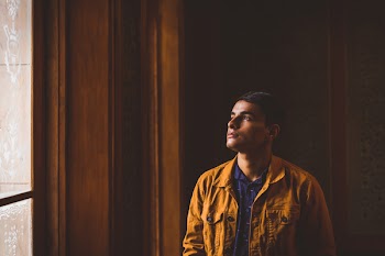 Photo of Man Looking Towards Window