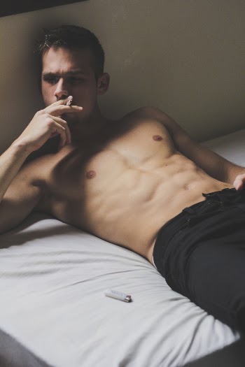Photo of Man Lying On Bed While Smoking