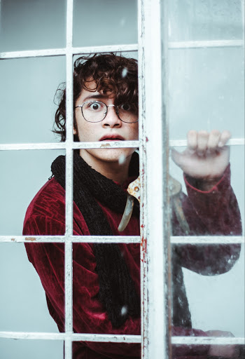 Photo of Man Near Window Pane