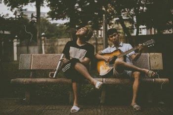 Photo of Man Playing Guitar Beside Another Man