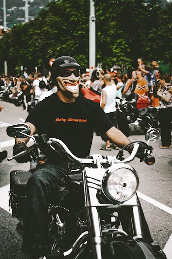 Photo of Man Riding Motorcycle While Wearing Mask