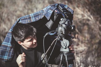 Photo of Man Setting Up Dslr Camera on Tripod