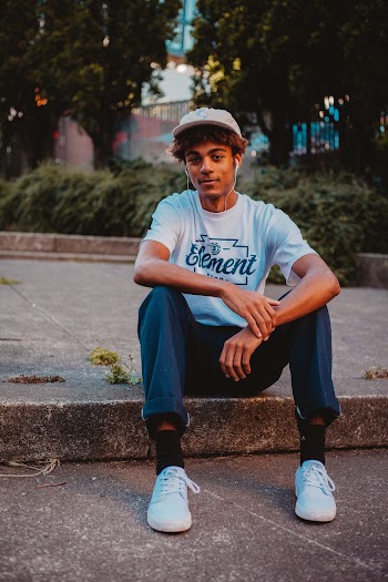 Photo of Man Sitting Alone on Concrete Curb Posing
