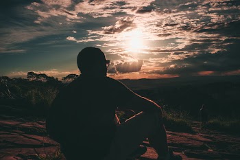 Photo of Man Sitting During Golden Hour