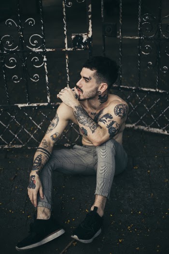 Photo of Man Sitting In Front Of Gate
