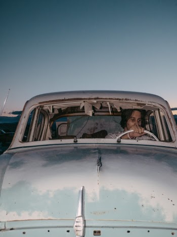 Photo of Man Sitting Inside Old Abandoned Classic Car