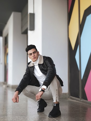 Photo of Man Sitting Near Wall