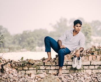 Photo of Man Sitting On Broken Brickwalls