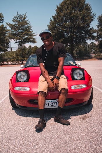 Photo of Man Sitting on Car Hood
