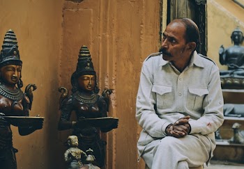 Photo of Man Sitting On Chair Near Statue