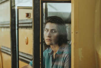Photo of Man Sitting on Doorway of School Bus
