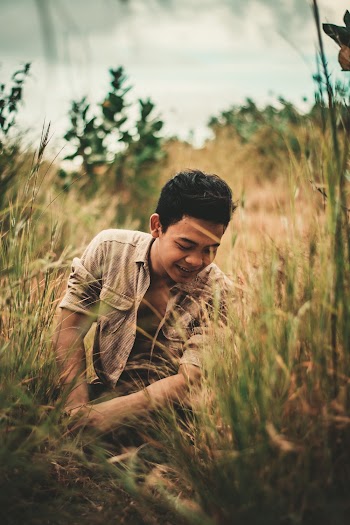 Photo of Man Sitting on Grass Field