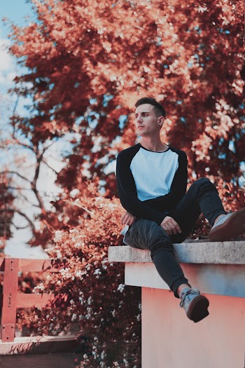 Photo of Man Sitting on Ledge