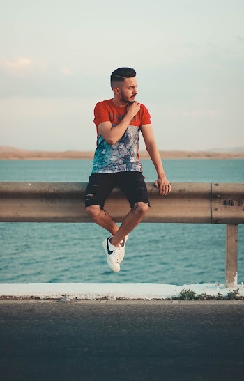 Photo Of Man Sitting On Metal Rail 
