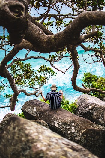 Photo Of Man Sitting On Rock