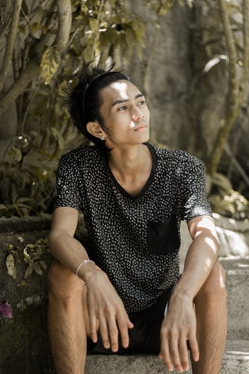 Photo of Man Sitting on Stairs Looking into the Distance