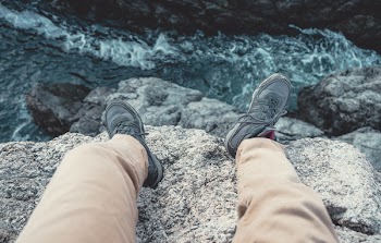 Photo of Man Sitting on the Cliff