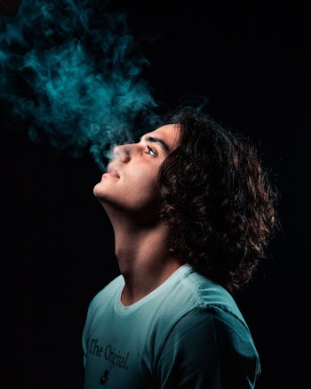 Photo of Man Smoking in Black Background