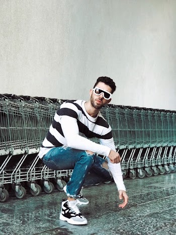 Photo of Man Squat Position in Front of Shopping Carts