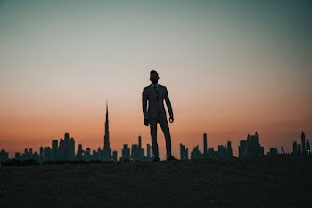 Photo of Man Standing Against City Buildings