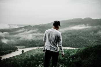Photo of Man Standing at the Edge of a Cliff