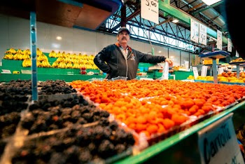 Photo of Man Standing Behind His Stall