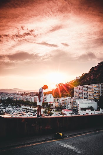 Photo of Man Standing Beside Road During Golden Hour
