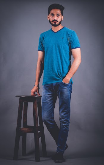 Photo of Man Standing Beside Wooden Stool