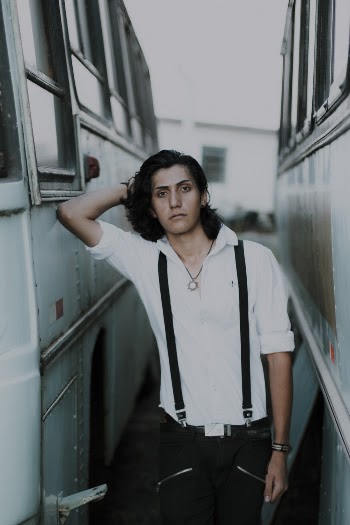 Photo of Man Standing Between Buses Posing