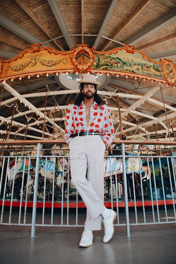 Photo Of Man Standing In Front Of Carousel