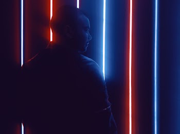 Photo of Man Standing in Front of Neon Lights