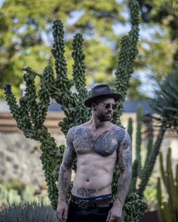Photo of Man Standing Near Cactus Plant