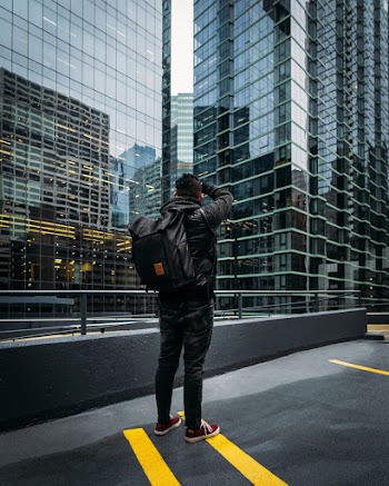 Photo of Man Standing Near High-rise Building