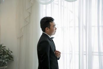 Photo Of Man Standing Near Window