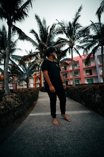 Photo of Man Standing on Gray Concrete Footpath Barefoot Looking Away