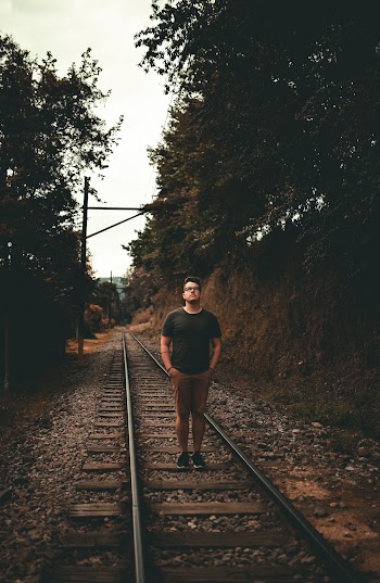 Photo of Man Standing On Railroad