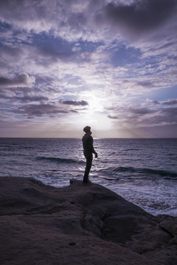 Photo of Man Standing on Rock Formation