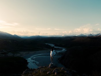 Photo of Man Standing on Rock Near Cliff Edge