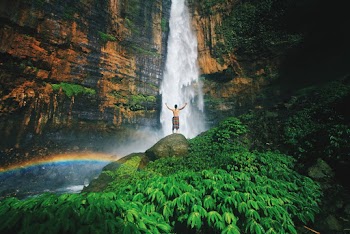 Photo Of Man Standing On Top Of Rock