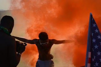Photo of Man Surrounded With Orange Smoke