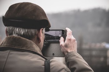 photo of man taking photo using camera