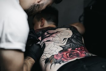 Photo Of Man Tattooing The Back Of Man