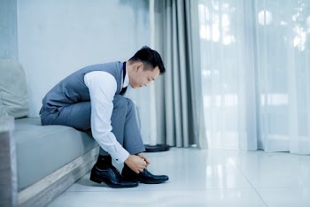 Photo of Man Tying His Shoes