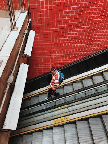 Photo of Man Walking Down Escalator
