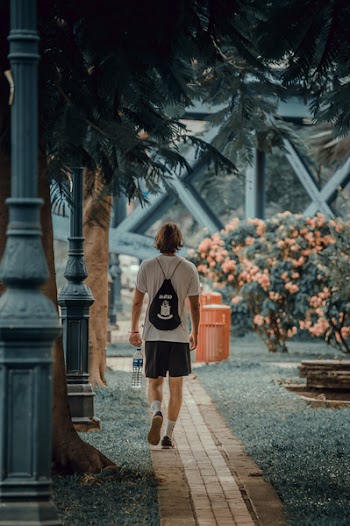 Photo of Man Walking on Pavement